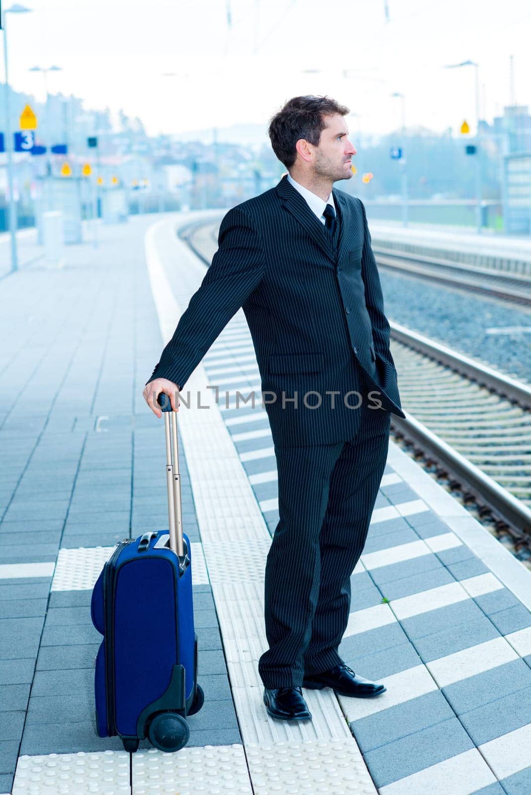 businessman in dark suit on railroad station