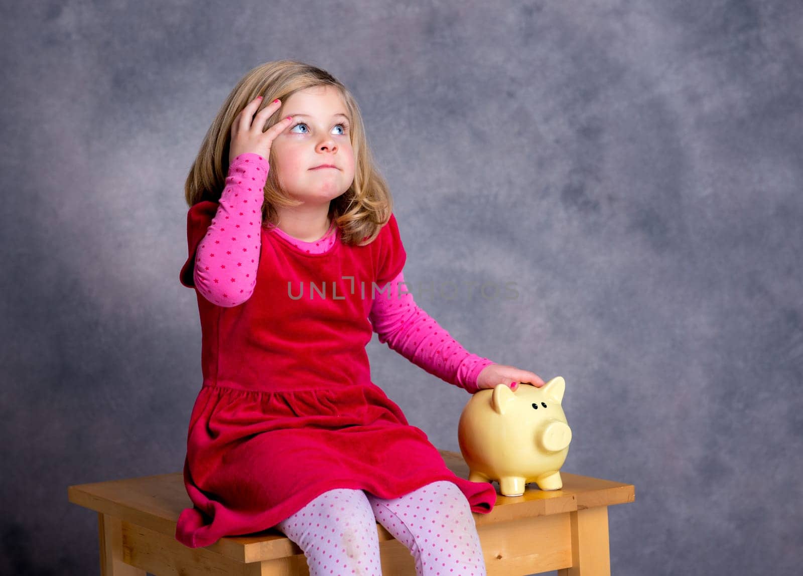 portrait of a smiling girl with piggy bank