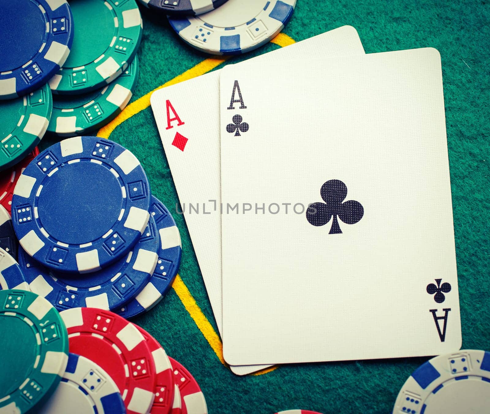 Stack of chips and two aces on the table on the green baize - poker game concept