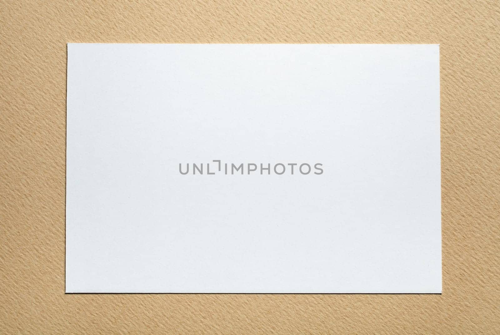 white paper card on beige background, place for tex