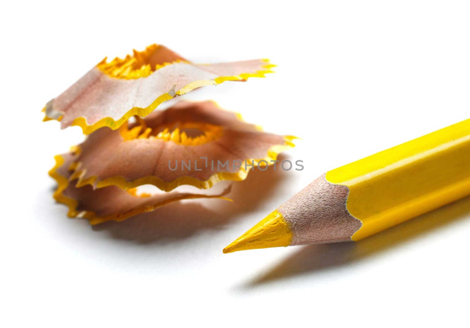 yellow pencil and shavings on white background
