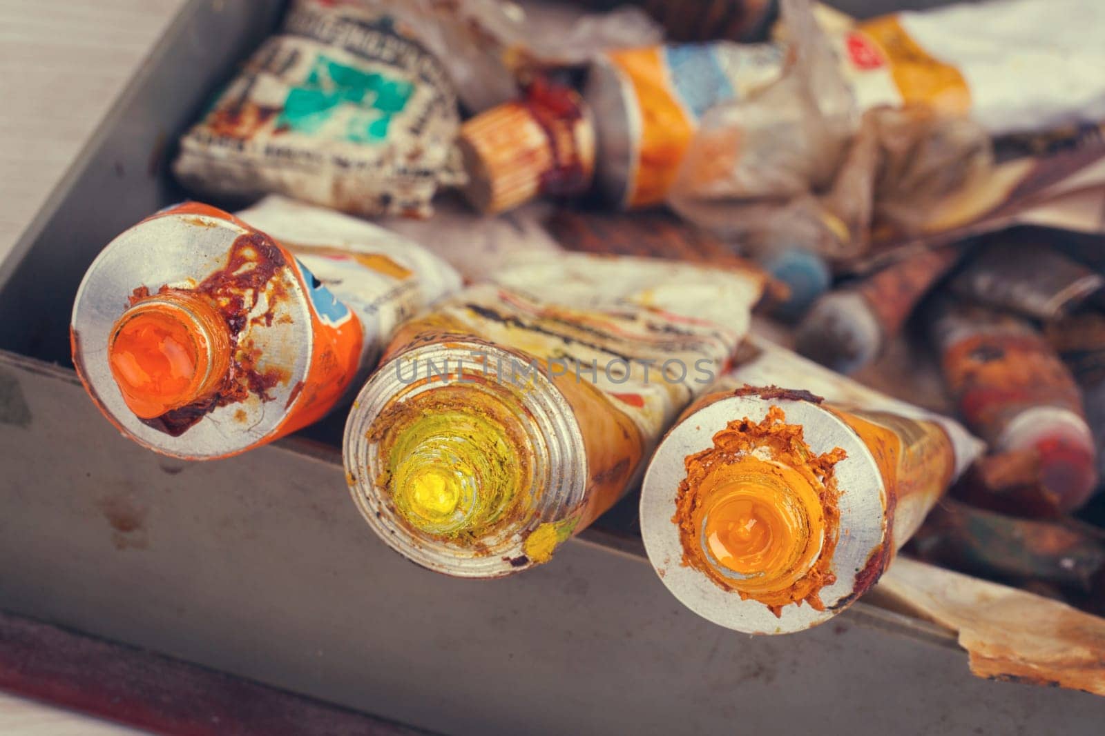 Old Paint tubes on painted tool background