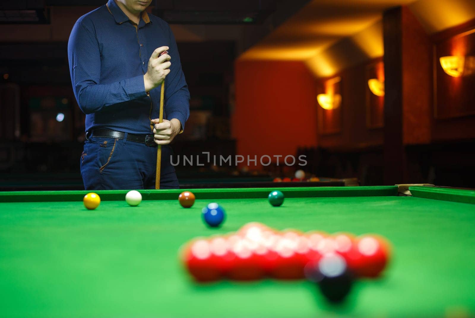 A young man lines up his shot as he breaks the balls for the start of a game of snooker