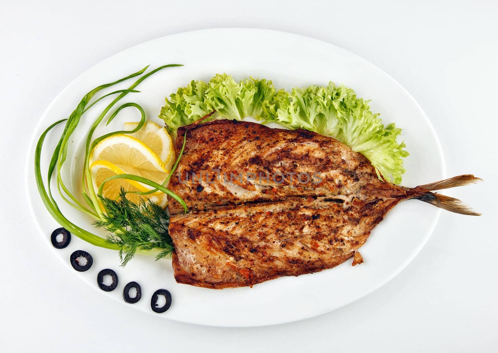 roast fish with lemon, onion and olives,lemon isolated