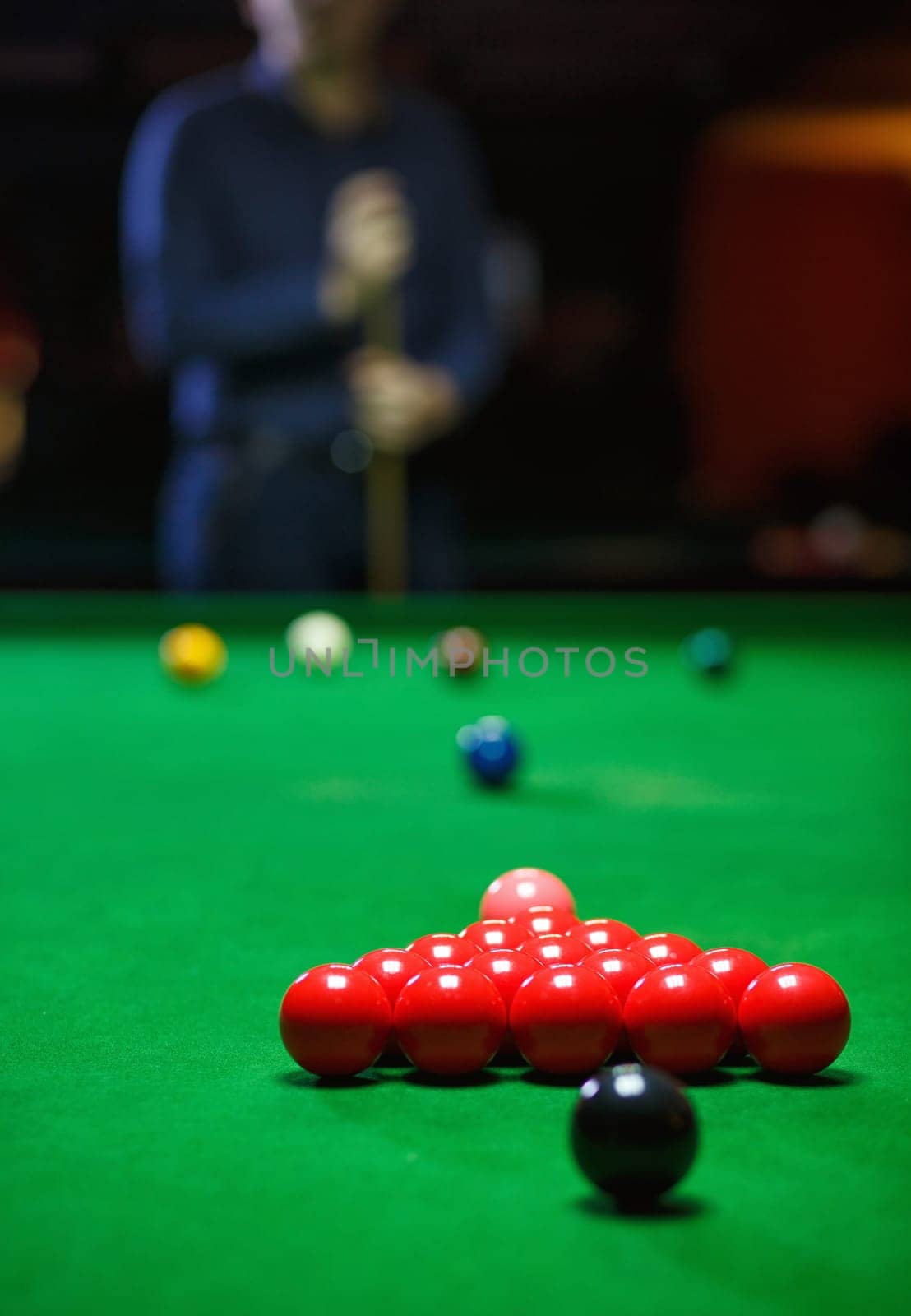 A young man lines up his shot as he breaks the balls for the start of a game of snooker