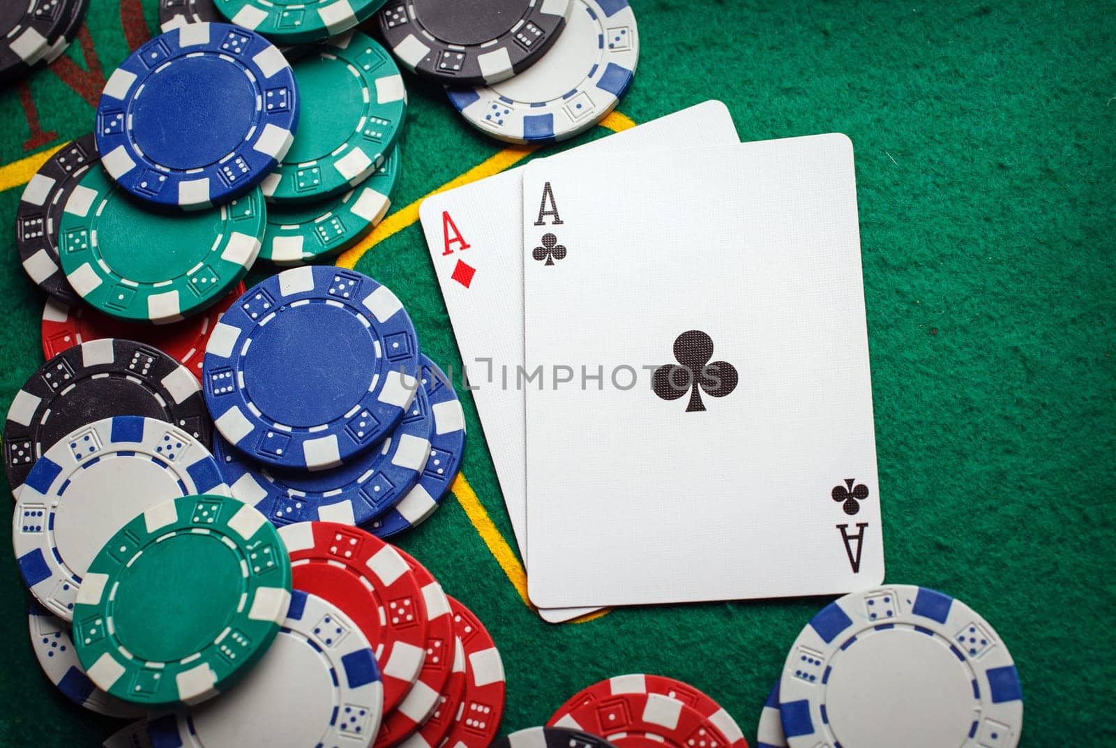 Stack of chips and two aces on the table on the green baize - poker game concept