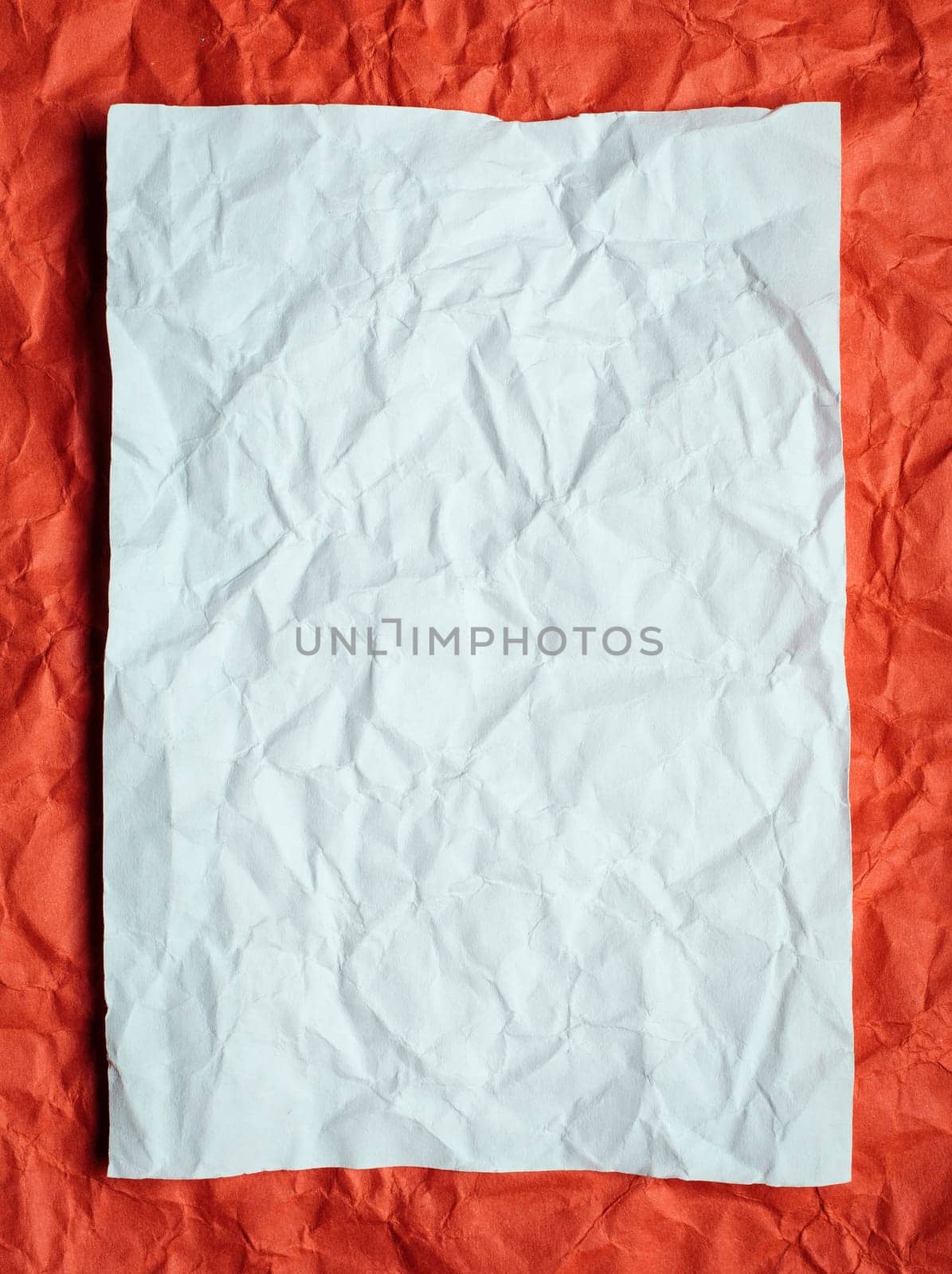 Crumpled  white paper card on red background, place for tex