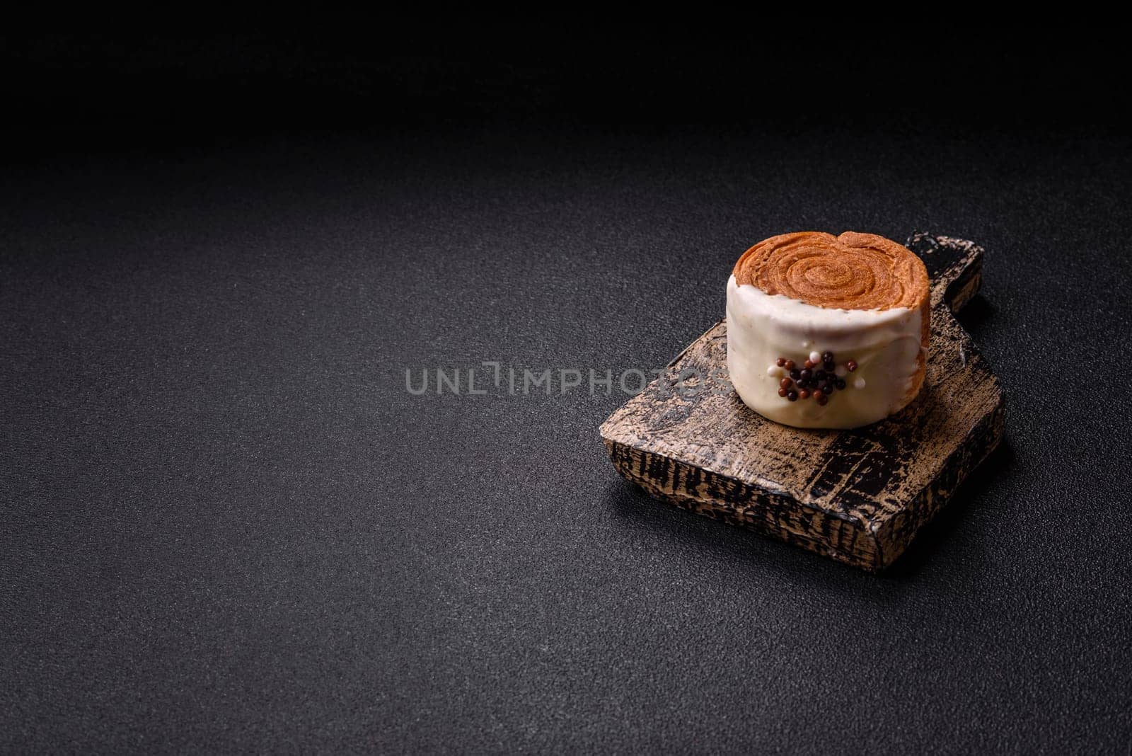 Round sweet New York roll croissant with pistachio cream filling on a dark concrete background