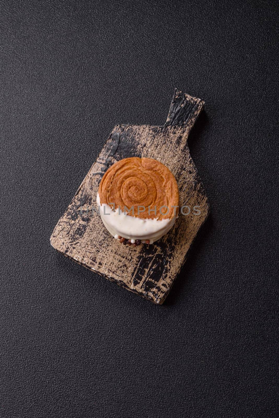 Round sweet New York roll croissant with pistachio cream filling on a dark concrete background