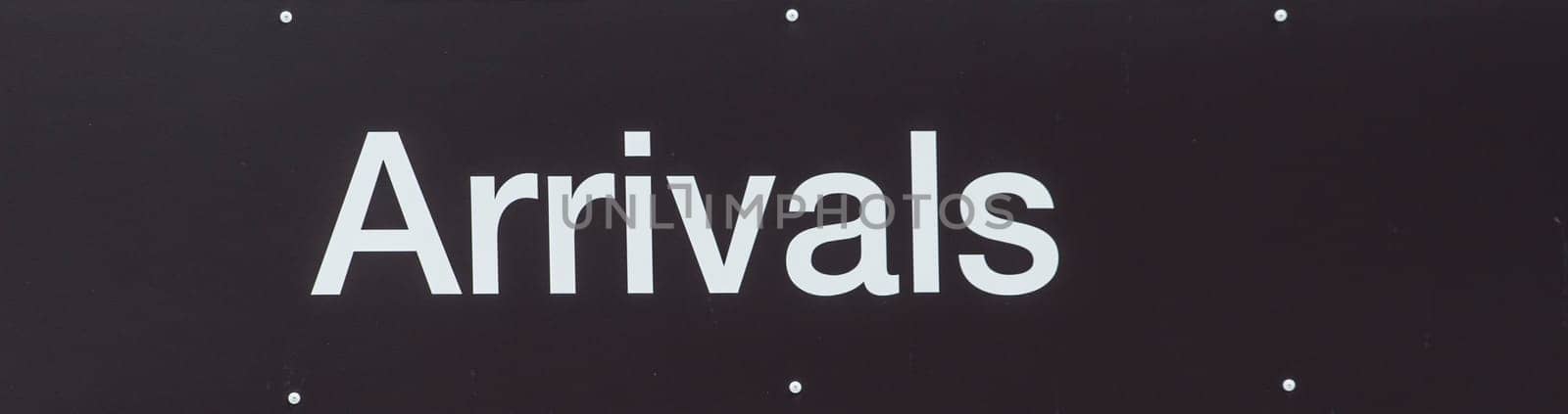 Black sign with white text showing Arrivals