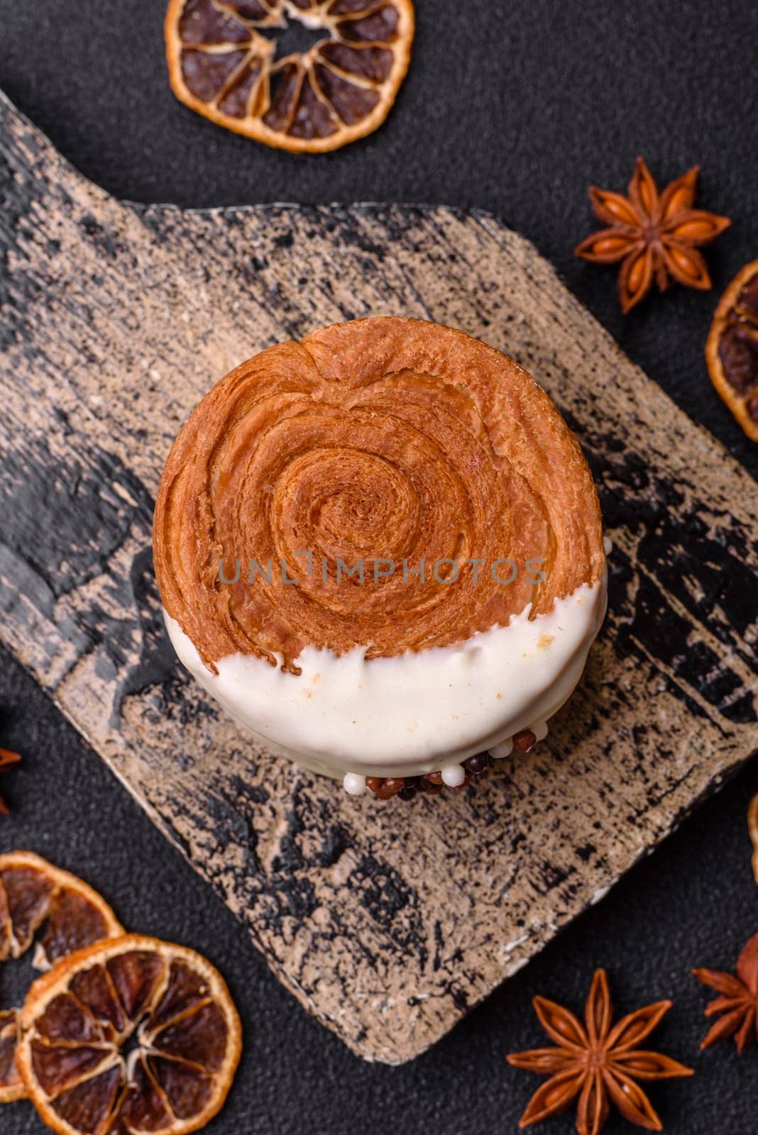 Round sweet New York roll croissant with pistachio cream filling on a dark concrete background