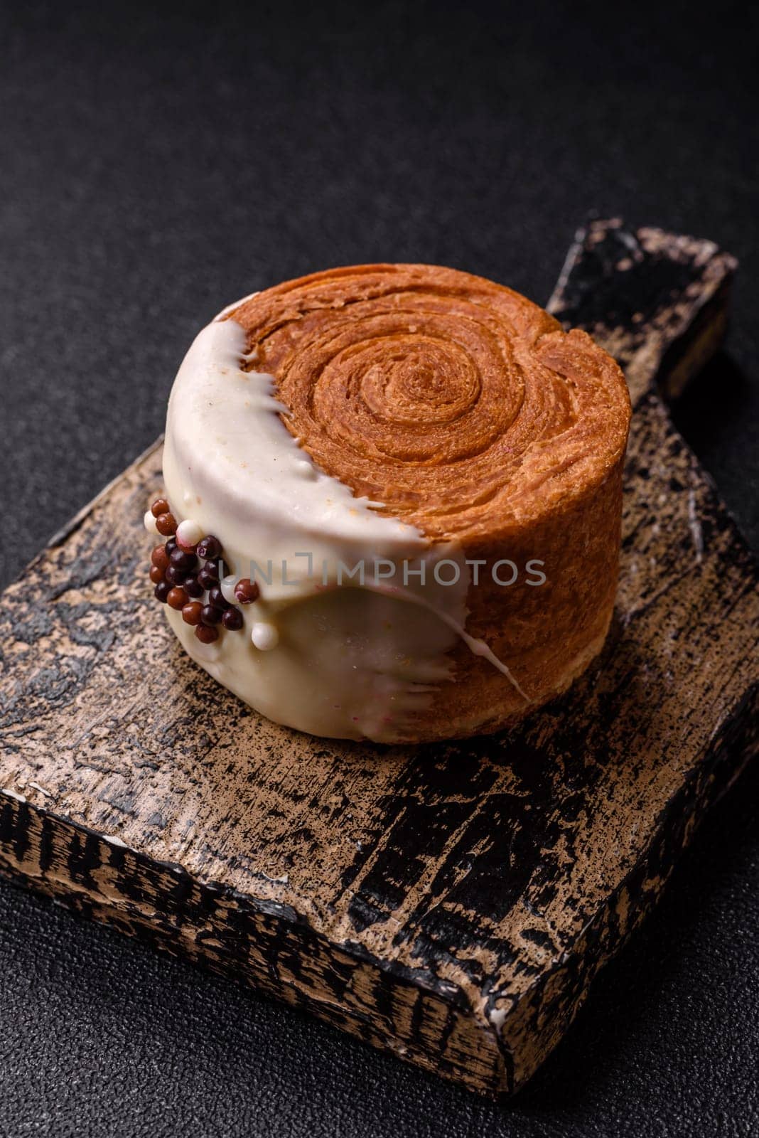 Round sweet New York roll croissant with pistachio cream filling on a dark concrete background