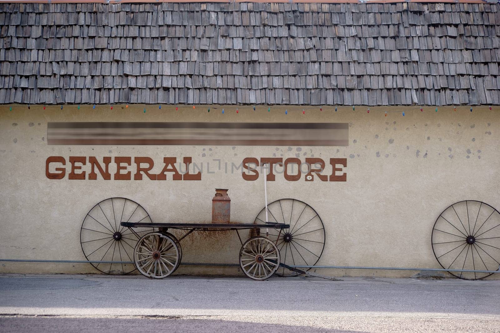 The facade of an old vintage shop with reclined old carriage wheels.