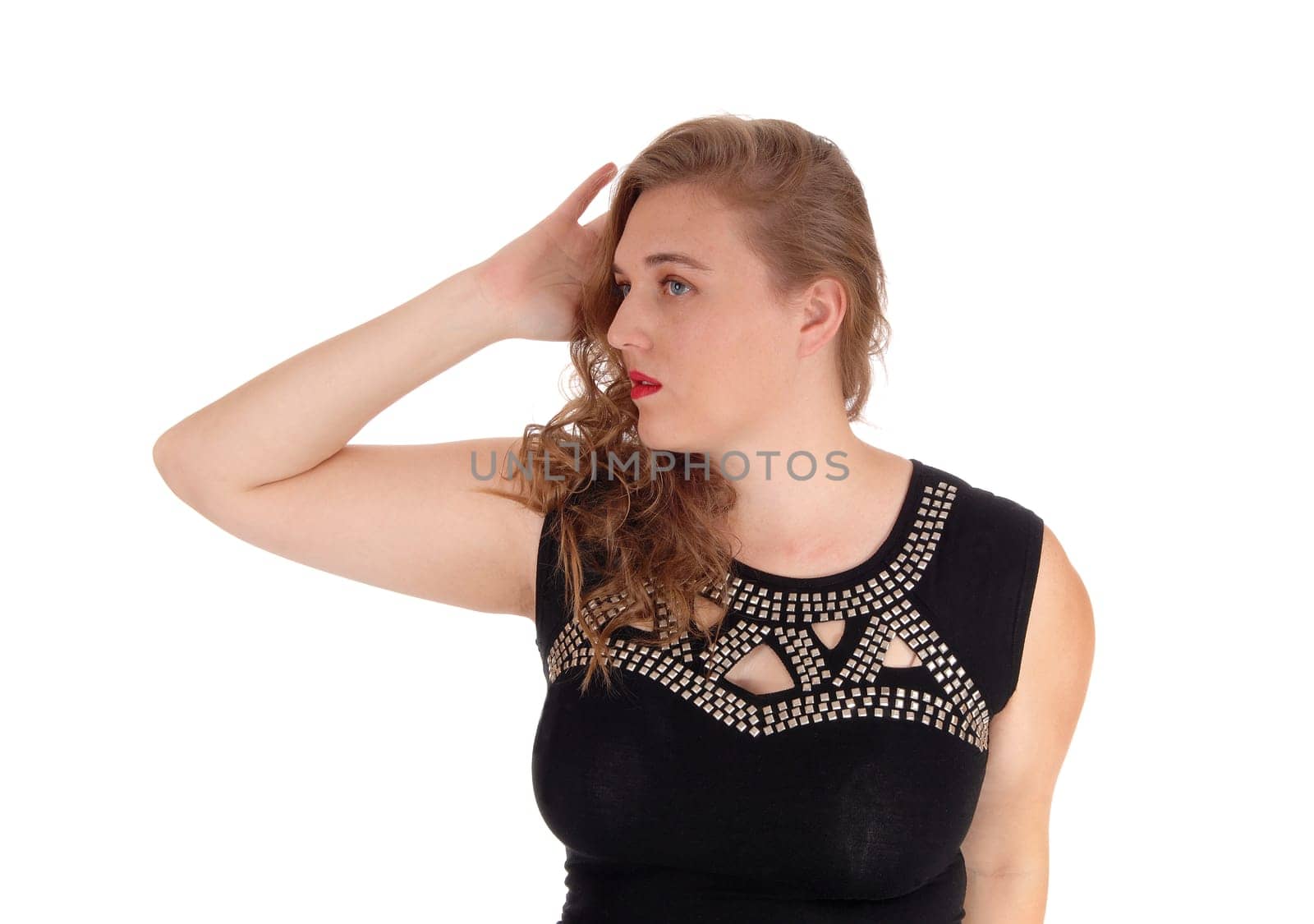 A pretty woman in a black dress standing in a portrait image isolated.for white background with one hand on her head..