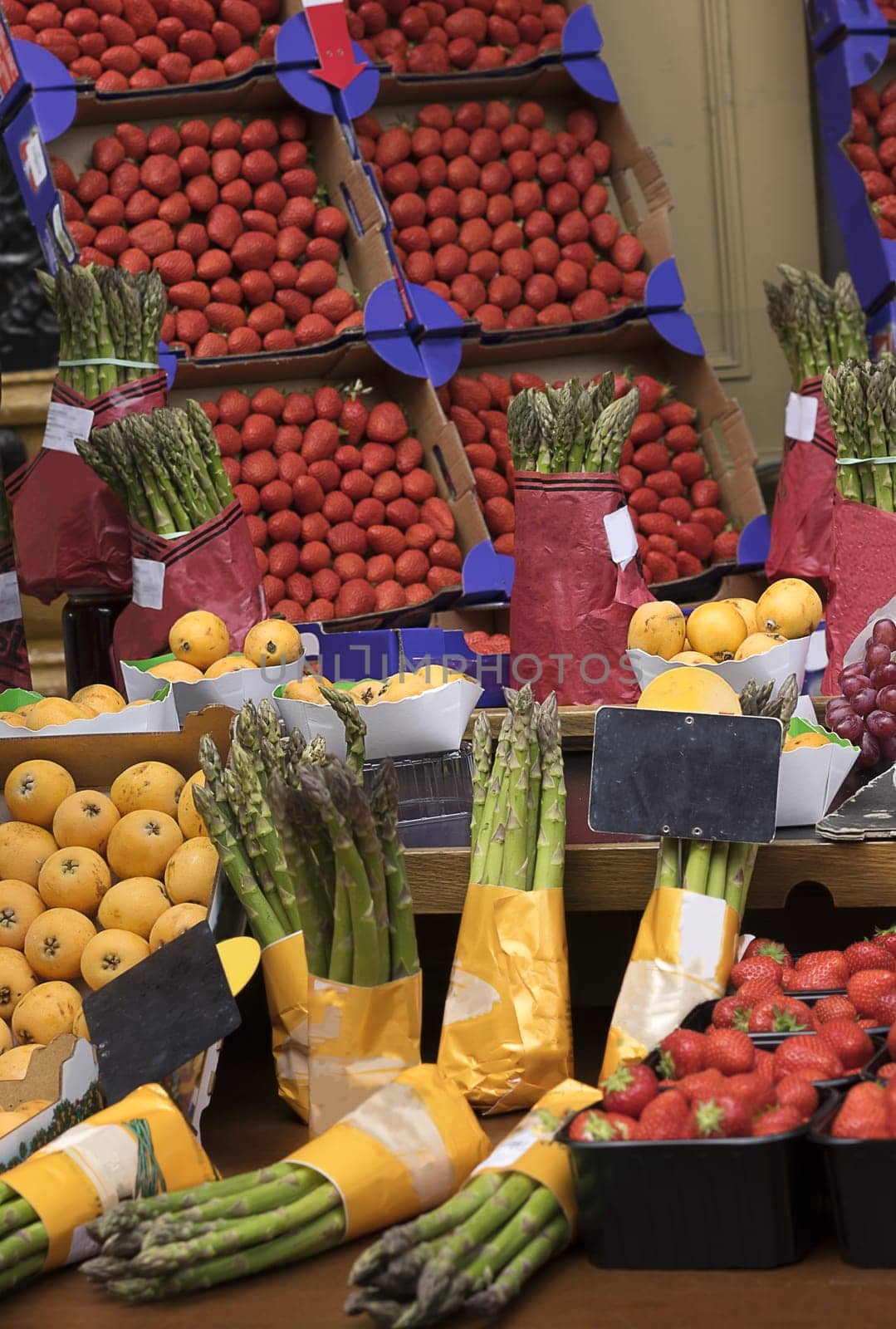 Fruit and vegetable stall with asparagus and strawberries, healthy nutritional food ingredients
