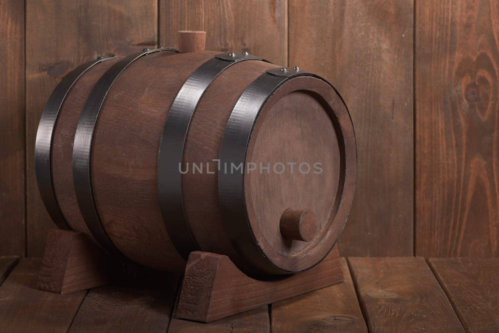 old wooden barrel with wooden plug on dark wood background