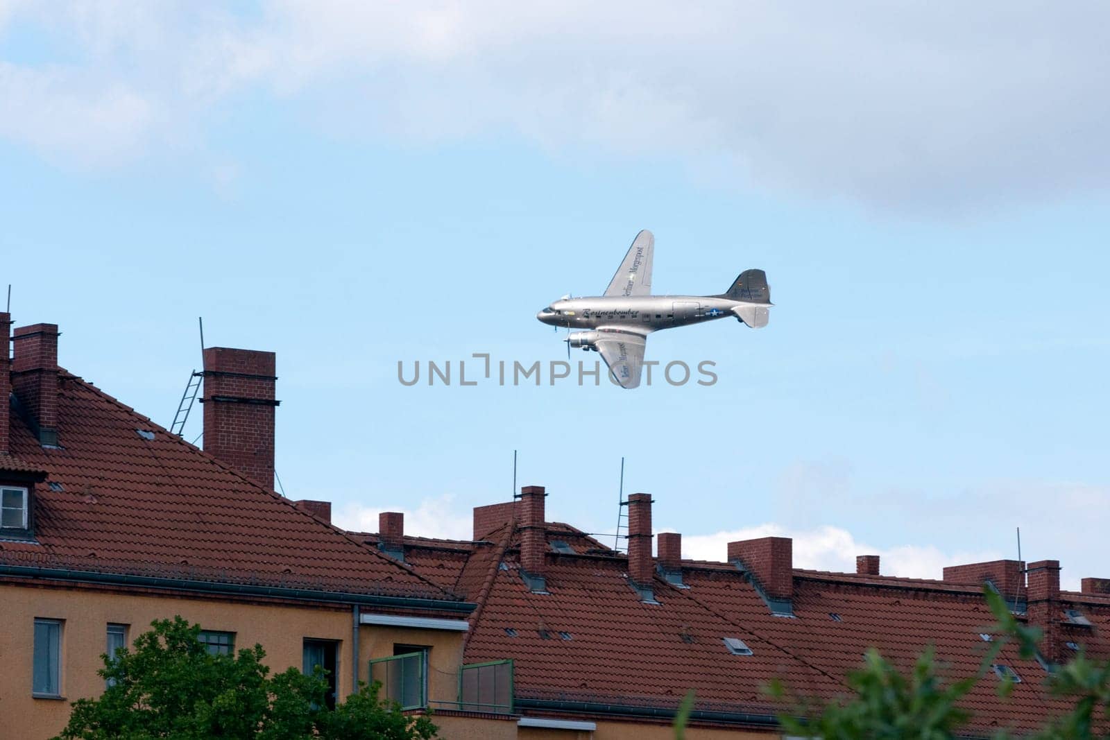 The raisin bomber throws small screens while flying over the former apron of Tempelhof airport for the 60th anniversary of the airlift celebration in Berlin-Tempelhof