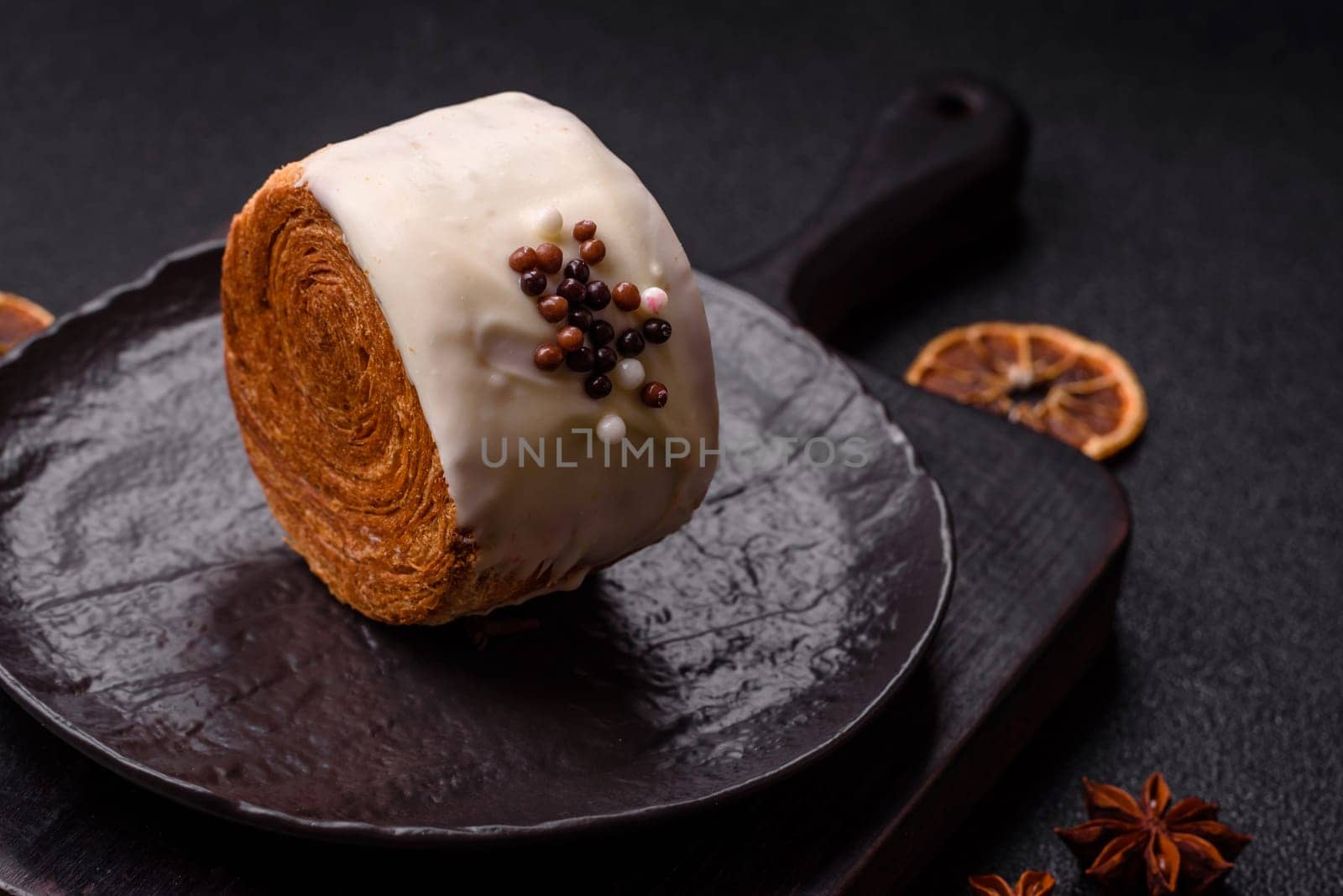Round sweet New York roll croissant with pistachio cream filling on a dark concrete background