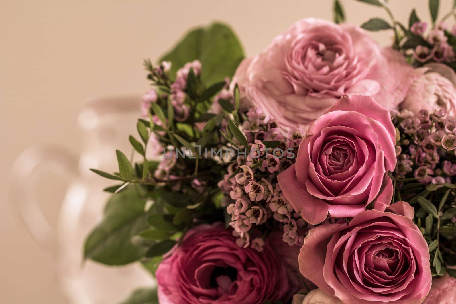 A great bouquet of roses in rose tones lies on the table waiting to be given away