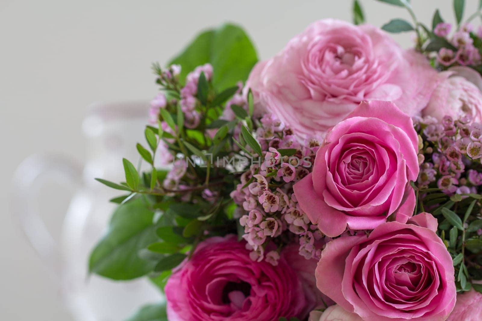 A great bouquet of roses in rose tones lies on the table waiting to be given away
