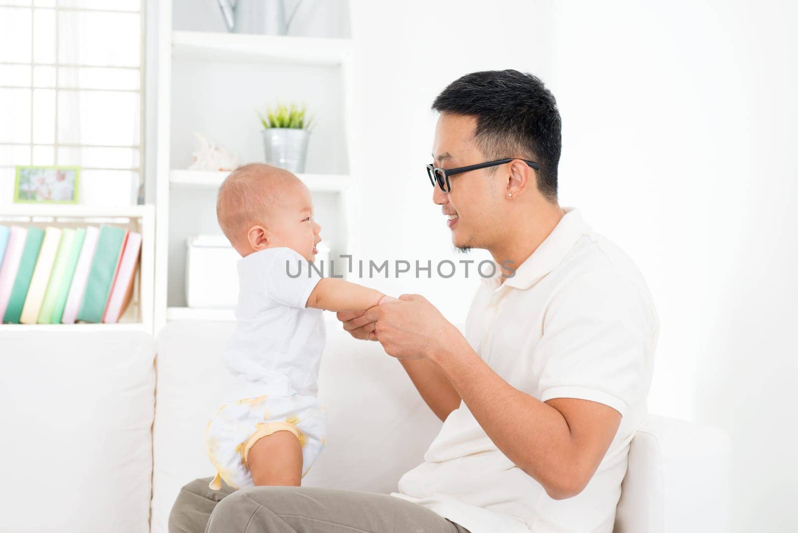 Father and baby boy playing at home. Southeast Asian family lifestyle indoors.