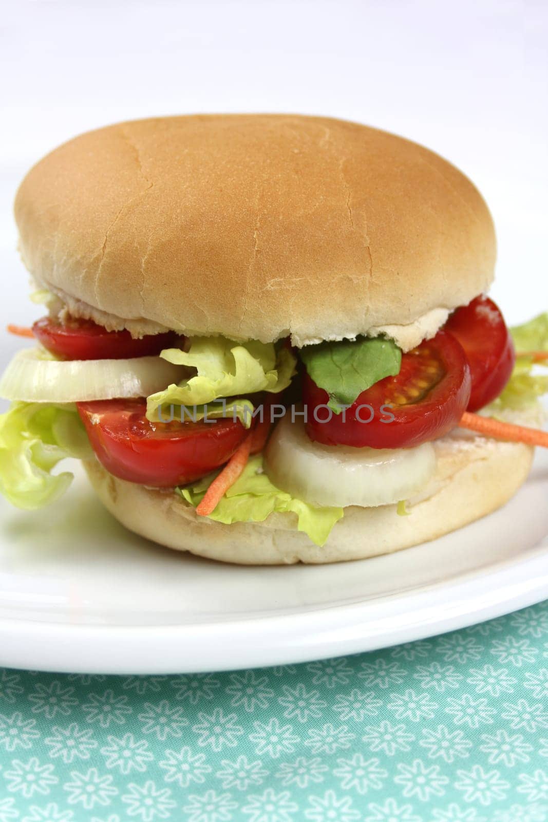 Hamburger rolls topped with tomatoes,onions and salad