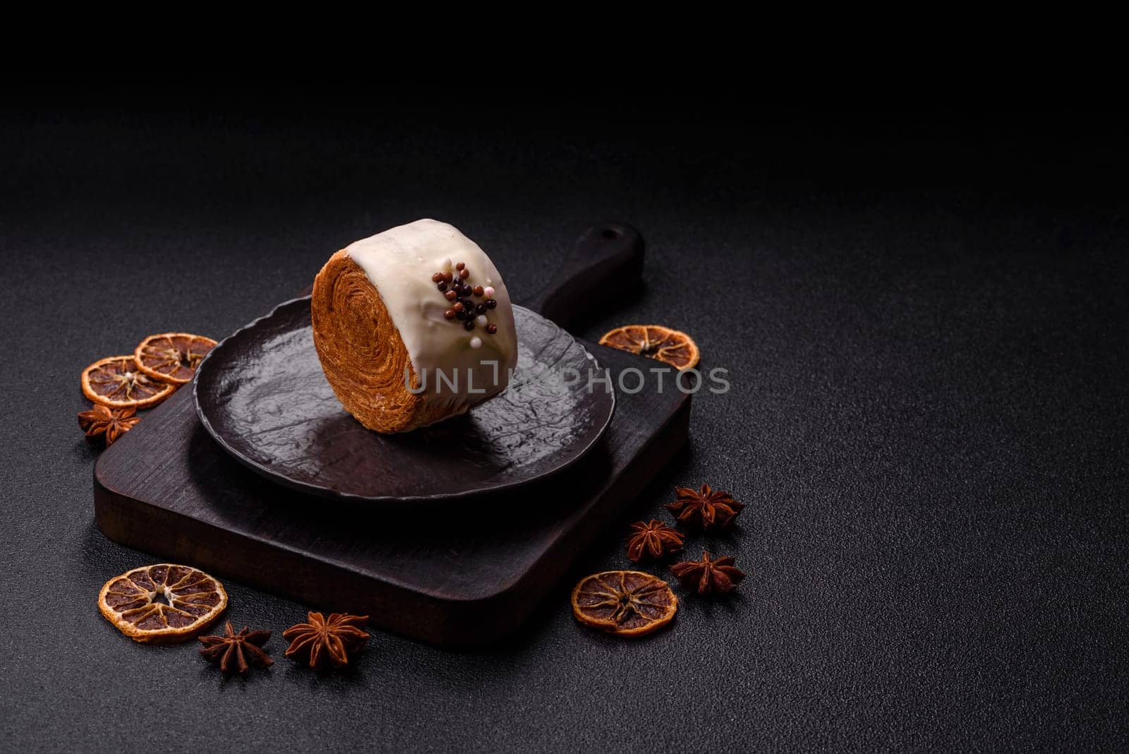 Round sweet New York roll croissant with pistachio cream filling on a dark concrete background