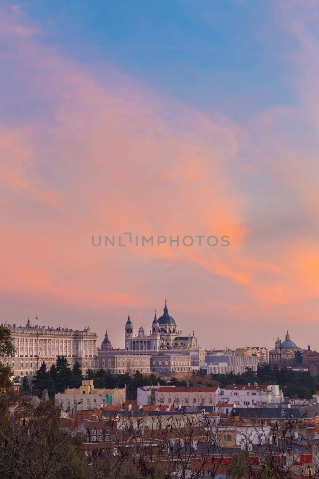 Madrid, Spain skyline at Santa Maria la Real de La Almudena Cathedral and the Royal Palace in vivid colorful sunset.