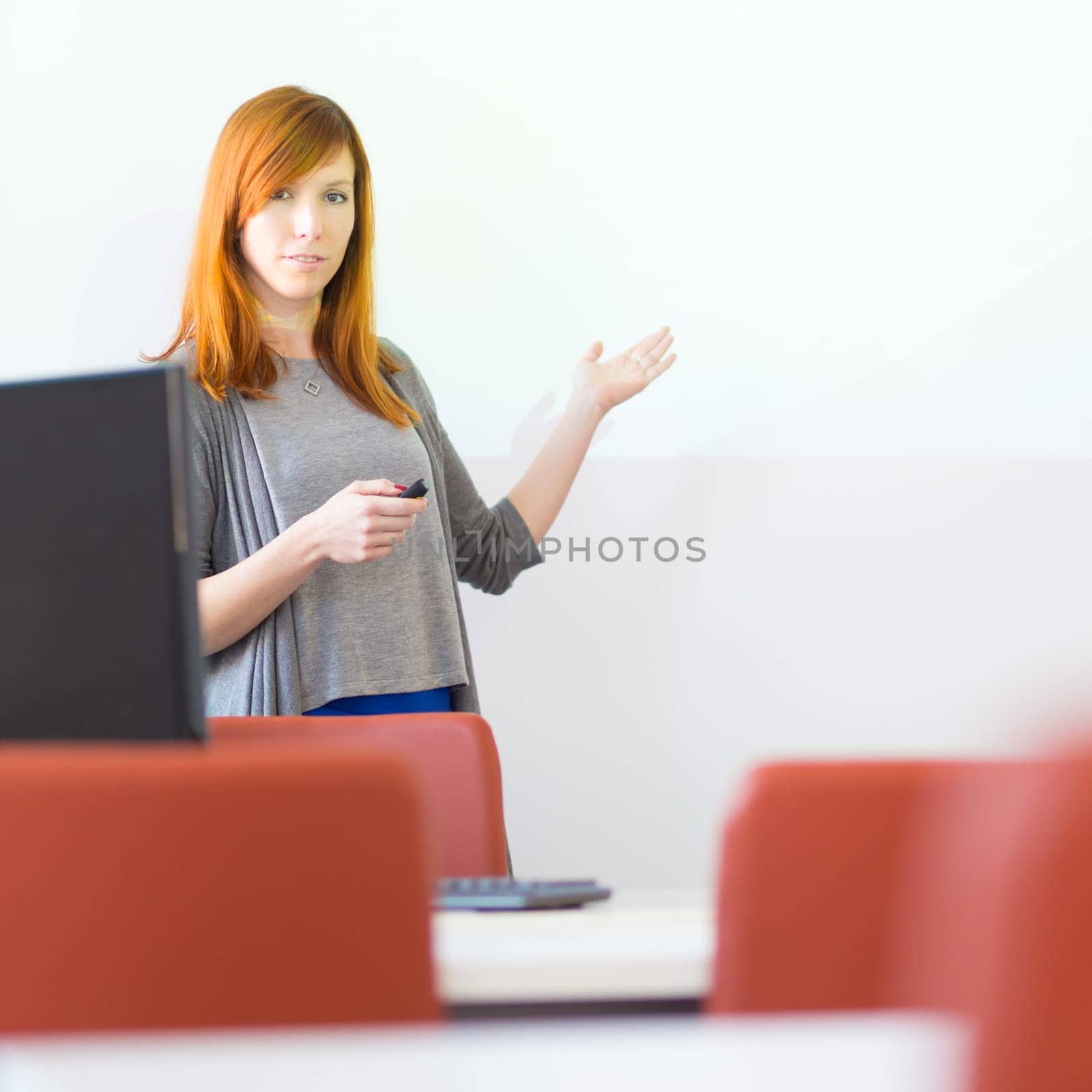 Female speaker giving presentation in lecture hall at university. Copy space for brand presentation.