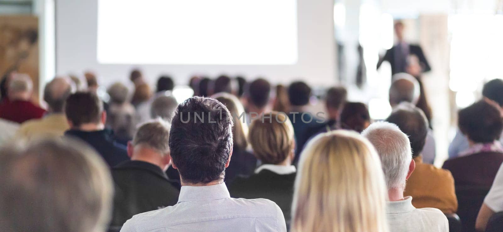 Speaker Giving a Talk at Business Meeting. Audience in the conference hall. Business and Entrepreneurship. Panoramic composition suitable for banners.