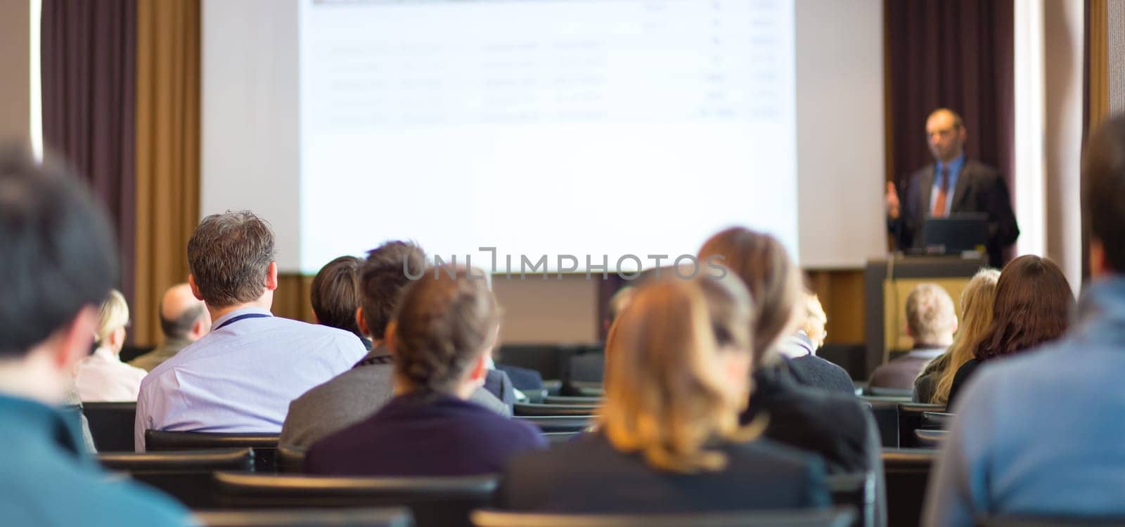 Speaker Giving a Talk at Business Meeting. Audience in the conference hall. Business and Entrepreneurship. Panoramic composition suitable for banners.