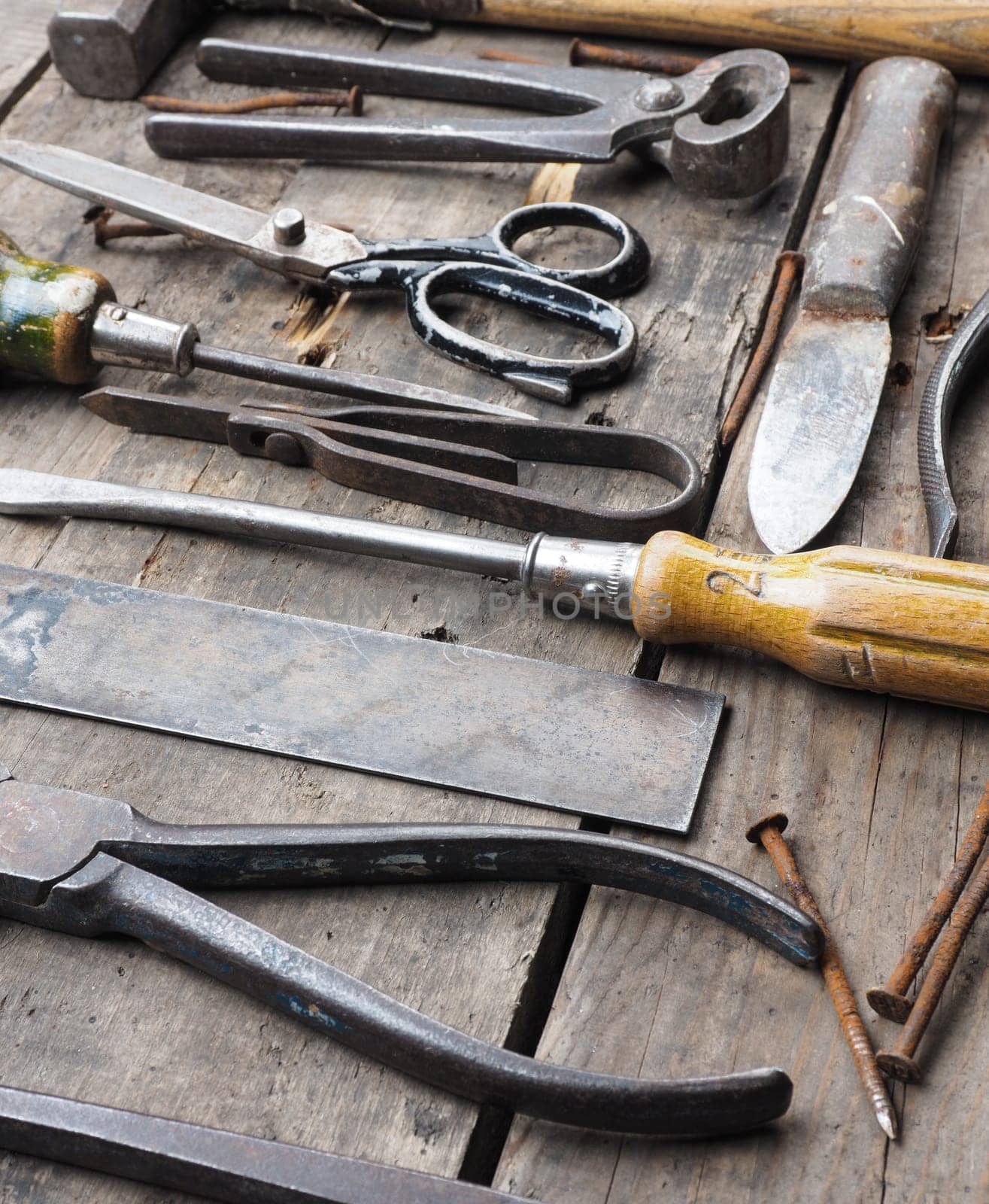 Old and rusty tools on a rustic wooden table
