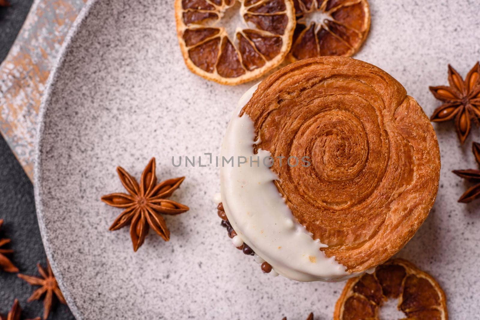Round sweet New York roll croissant with pistachio cream filling on a dark concrete background