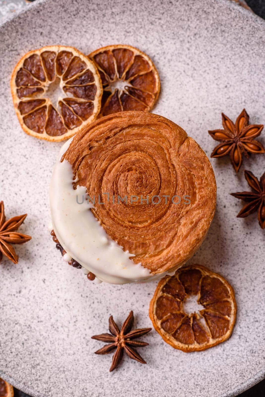 Round sweet New York roll croissant with pistachio cream filling on a dark concrete background