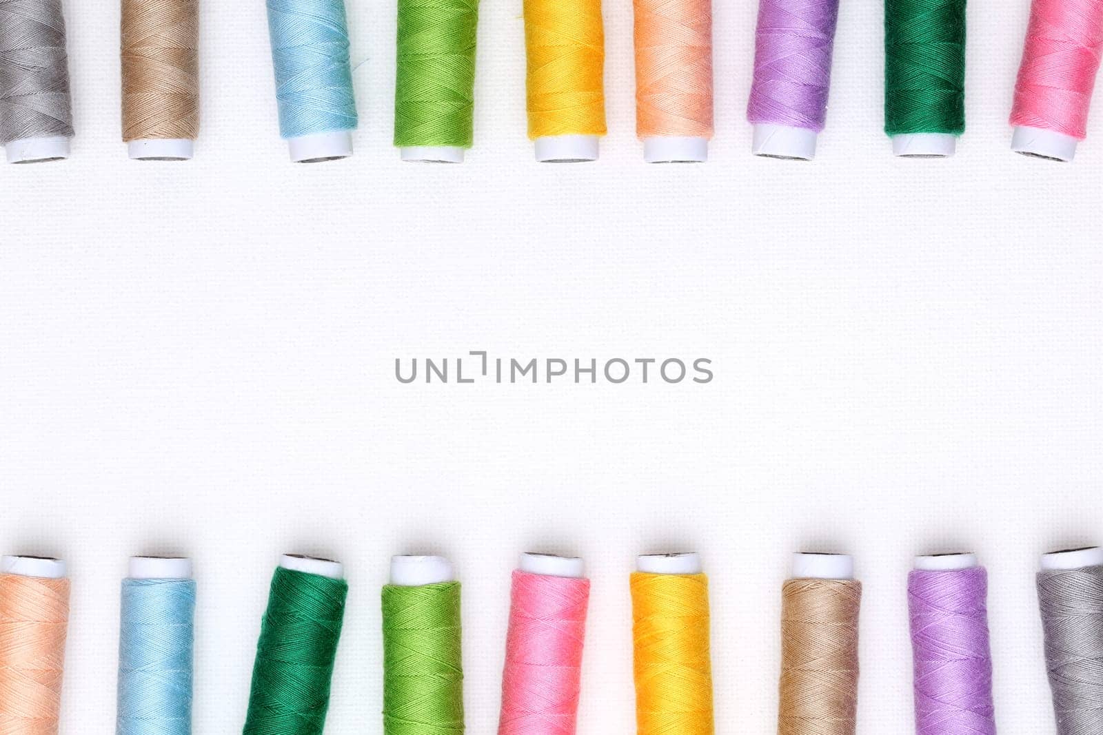 colorful spool of threads on white background