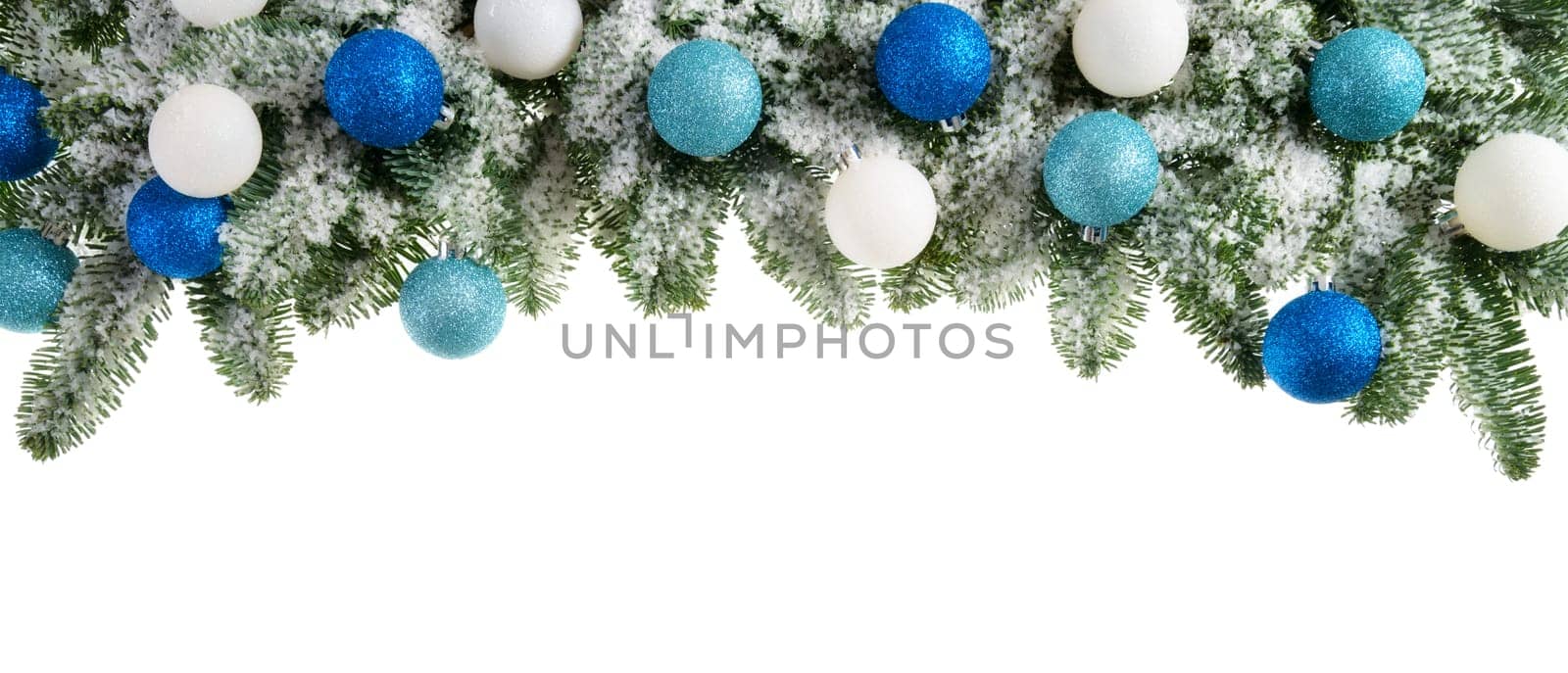 Decoration of snowy fir branches with Christmas balls on a white background