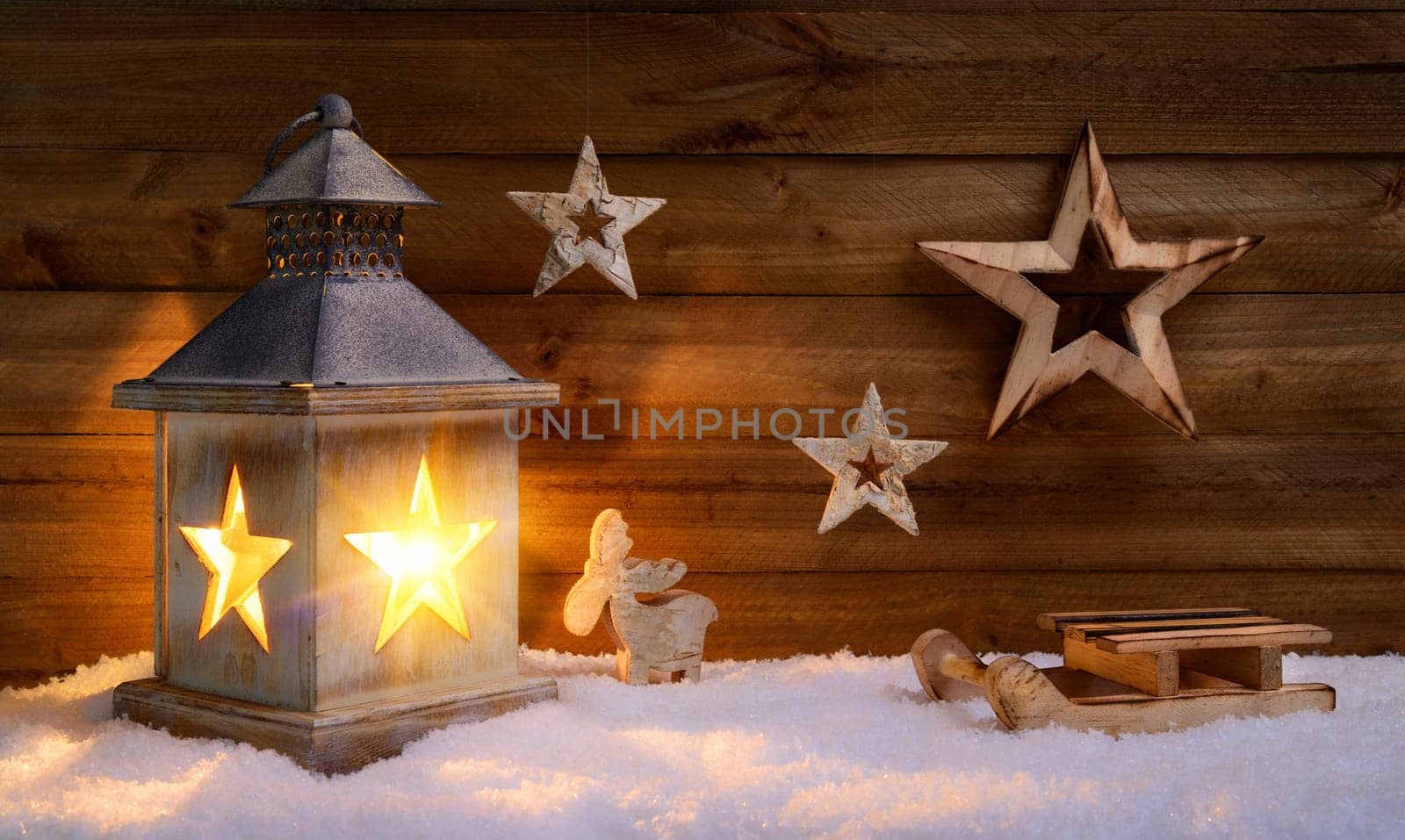 Christmas arrangement of beautiful wooden decoration and lantern on snow