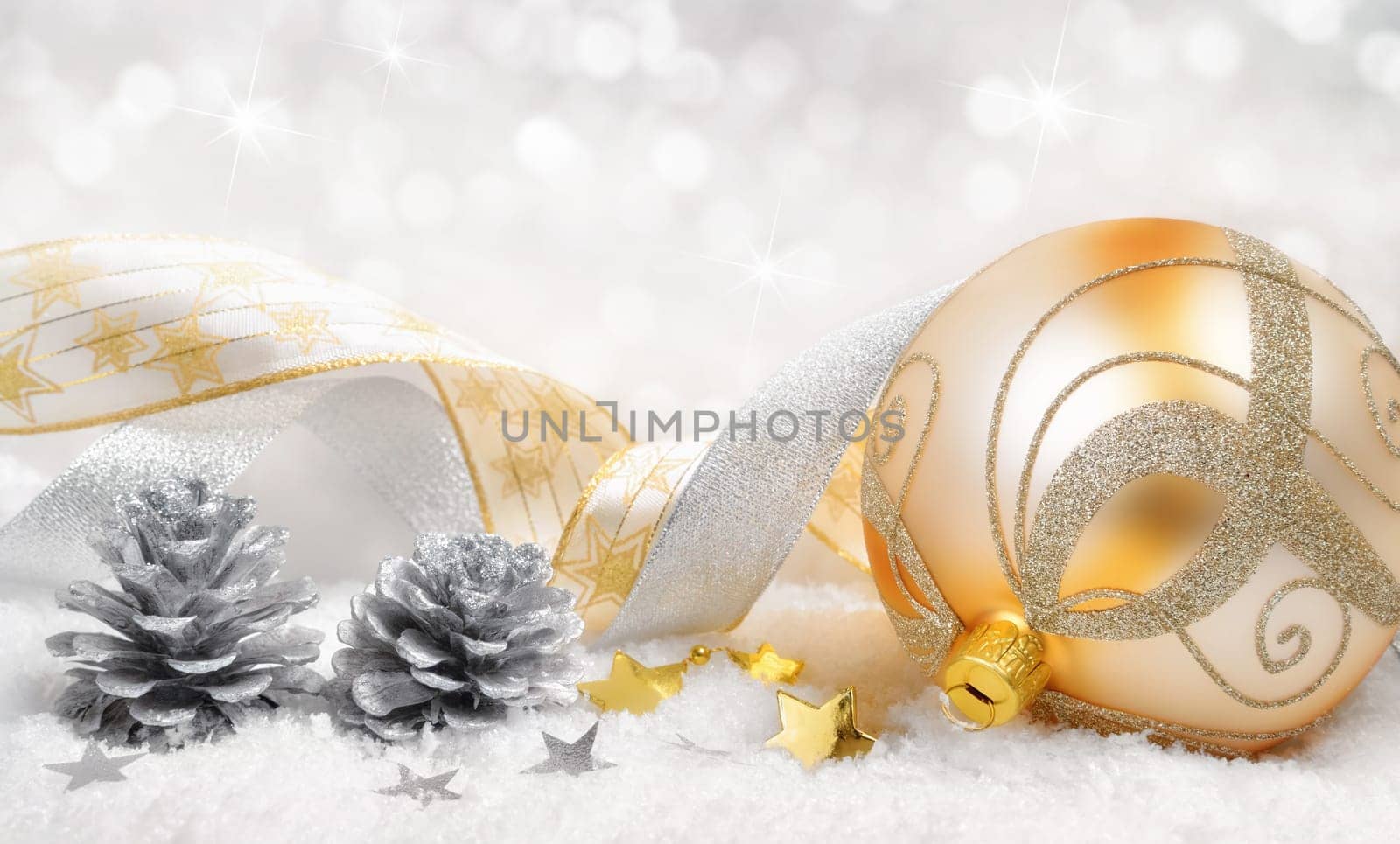 Dreamy Christmas arrangement with golden ball,decobe bands and pine cones on snow