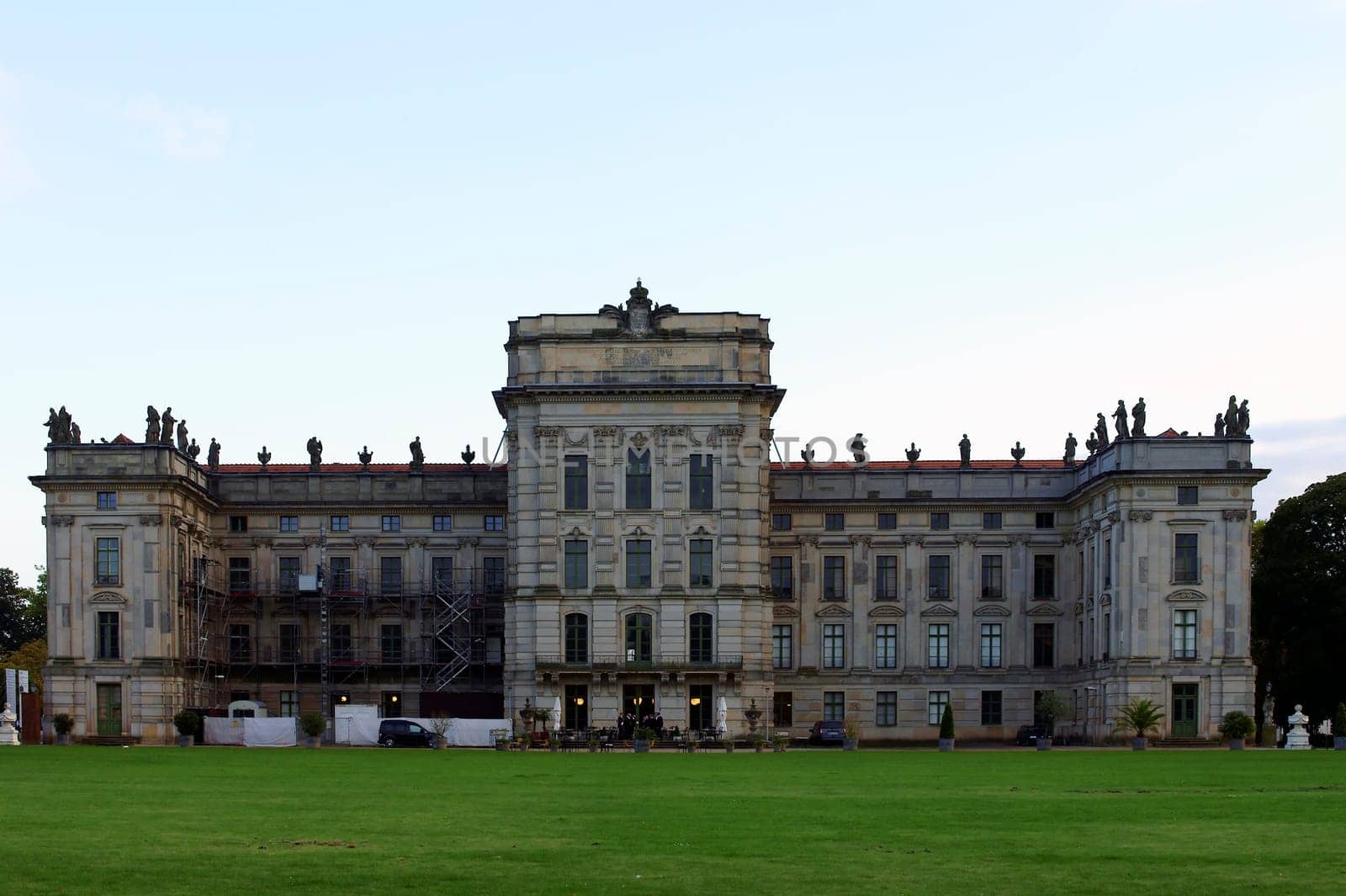 Ludwigslust,Germany – September 23,2014: The rear view of Ludwigslust Castle with a park adjacent lawn and scaffolding on the facade on September 23,2014 in Germany.
