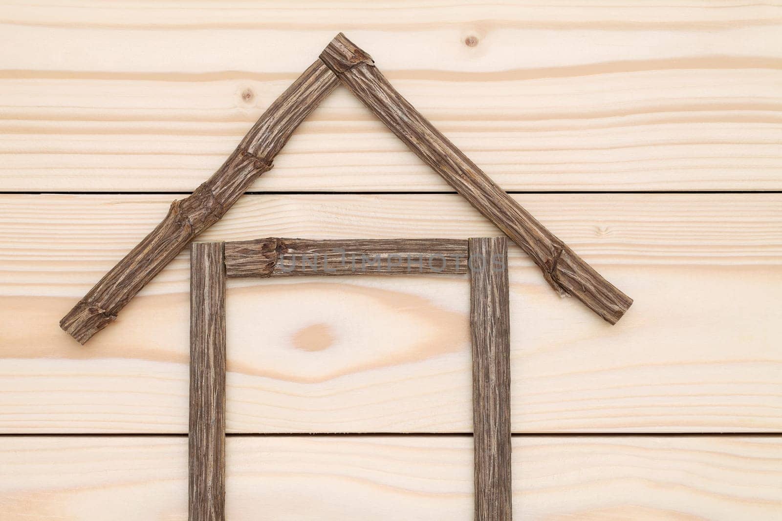 small house made of branches on wood background