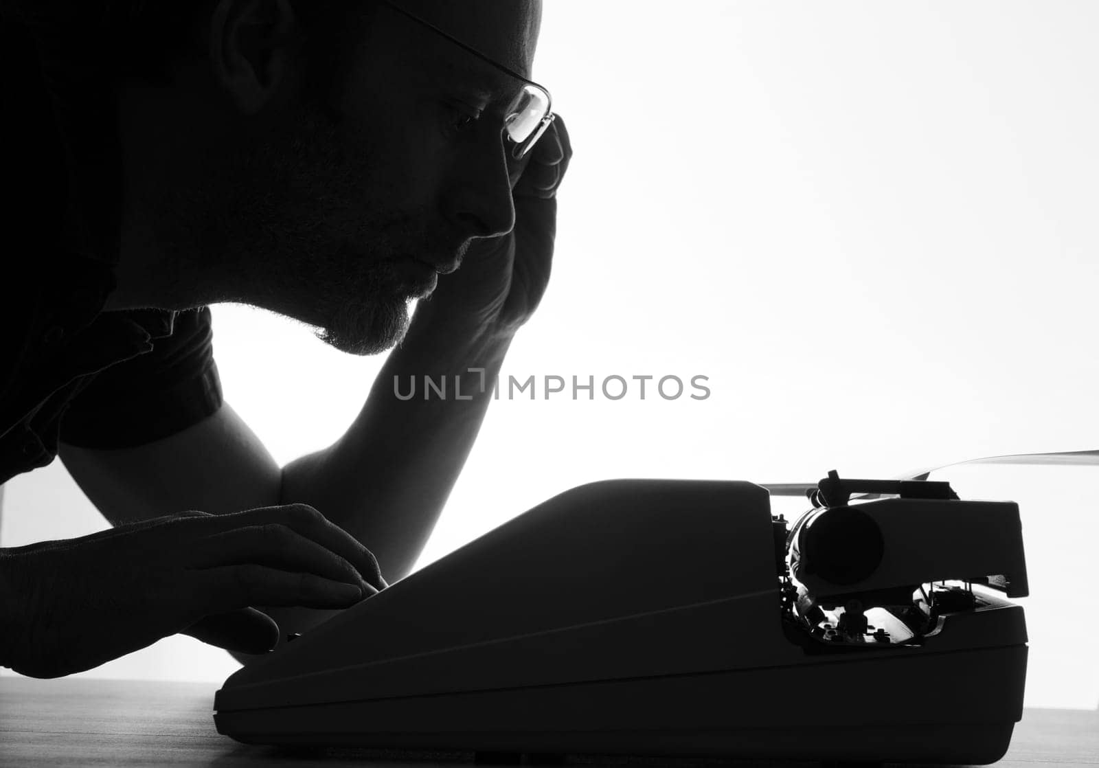 Man with an old typewriter, black and white with bright background