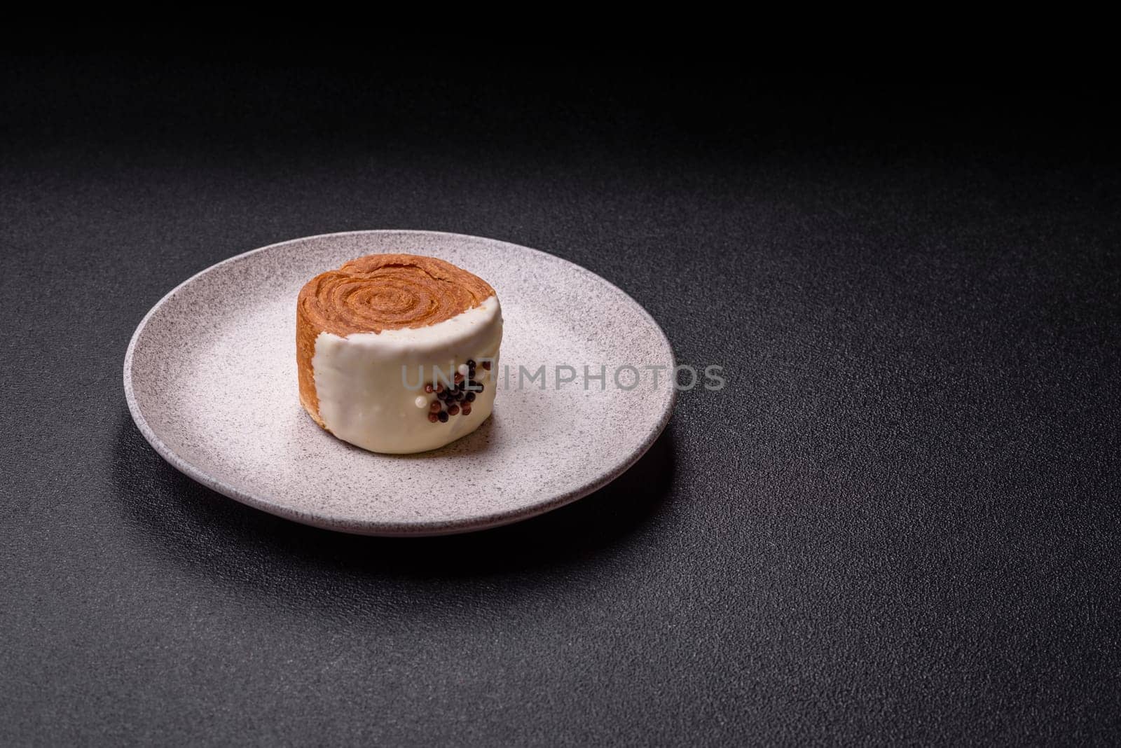 Round sweet New York roll croissant with pistachio cream filling on a dark concrete background