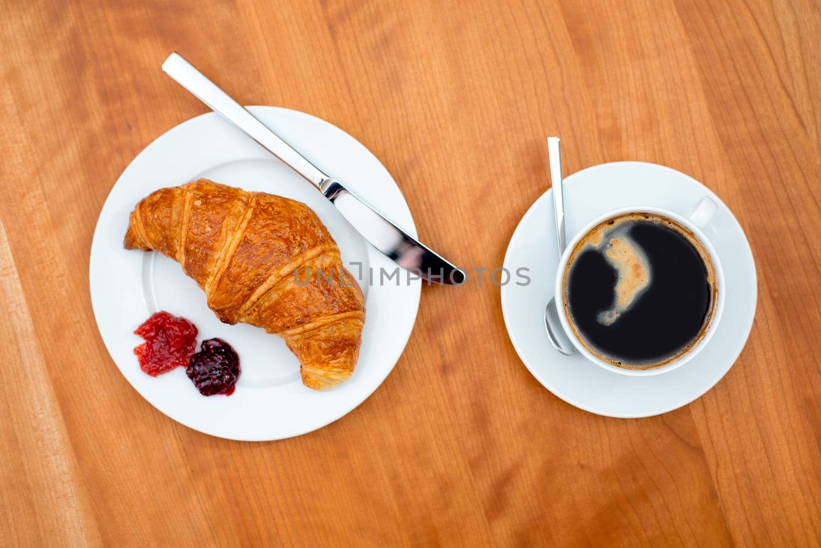 delicious croissant with coffee on wooden table from above