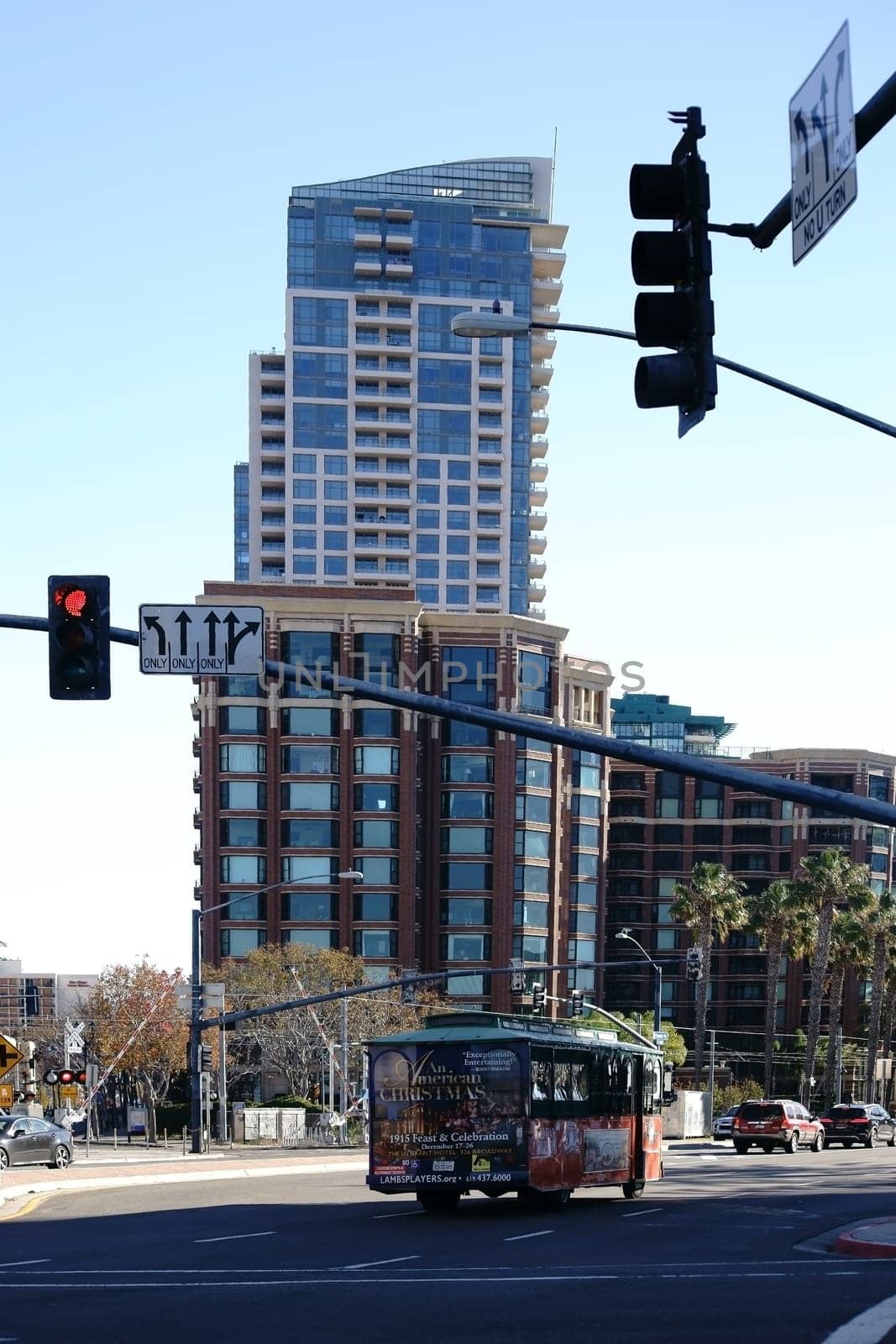 San Diego,United States - December 25,2015: A city tour bus crosses an intersection in downtown San Diego with an apartment skyscraper in the background on December 25,2015 in San Diego.