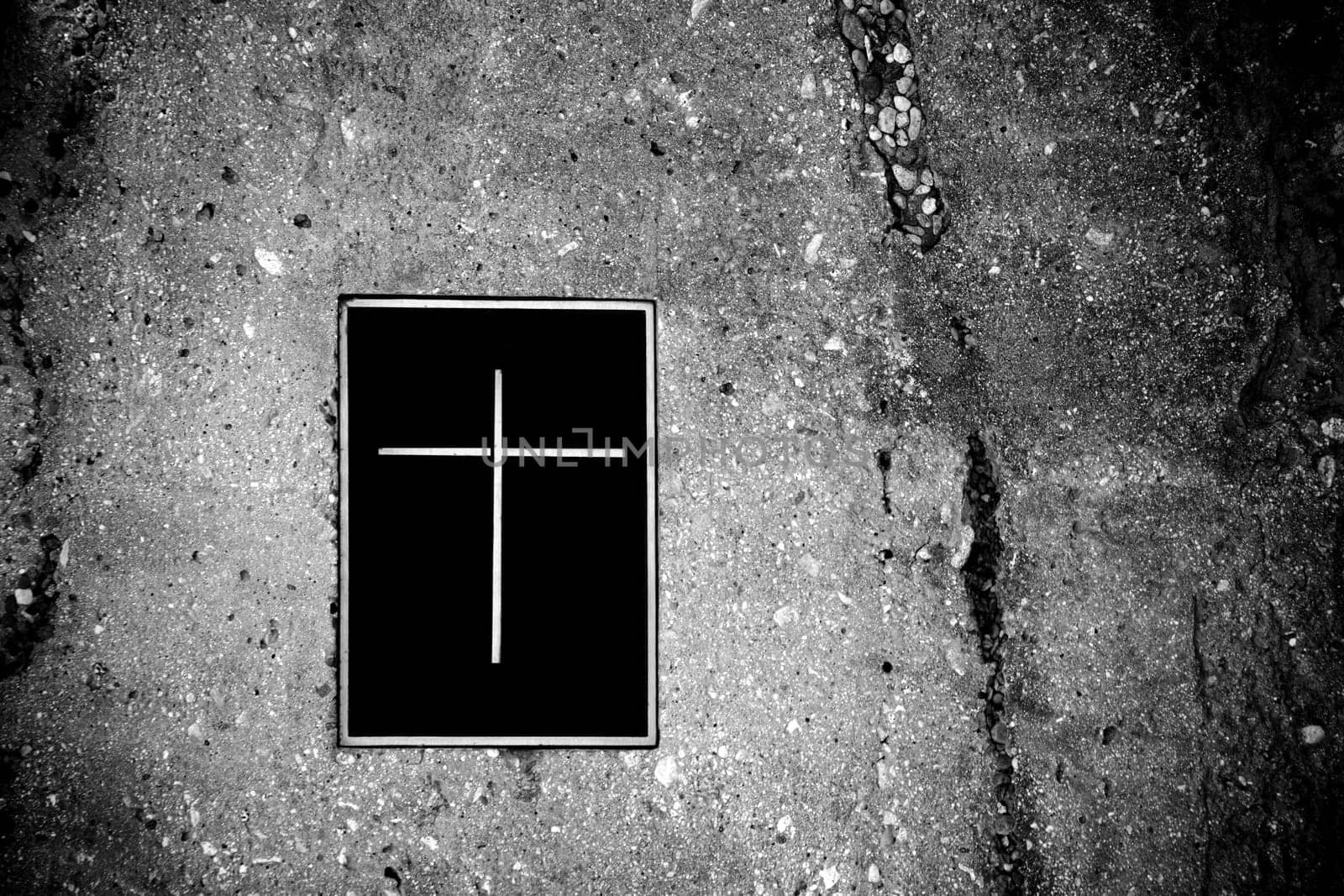 A grave embedded in rocks with a lid or closure with a cross symbol.