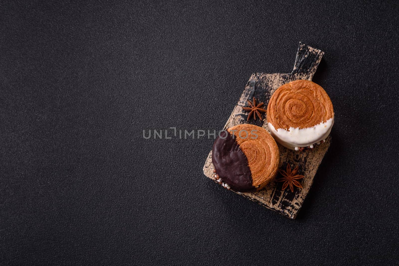 Round sweet New York roll croissant with chocolate cream filling on a dark concrete background