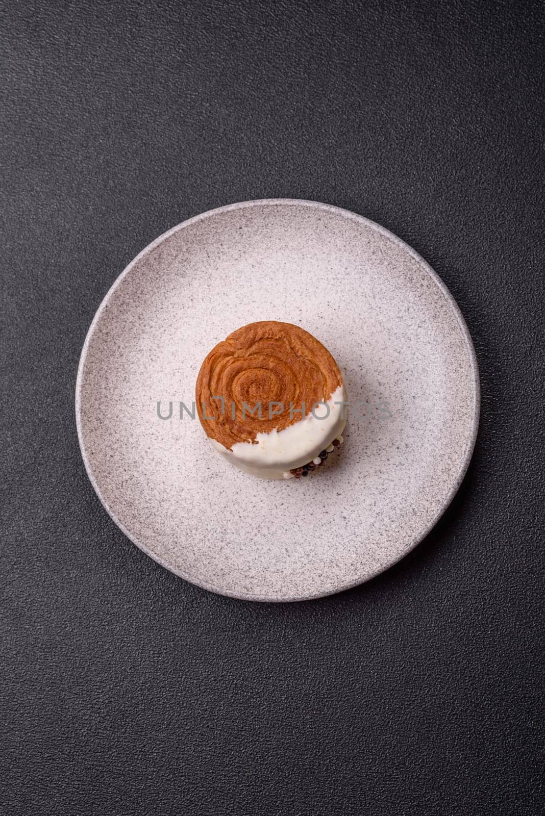 Round sweet New York roll croissant with pistachio cream filling on a dark concrete background