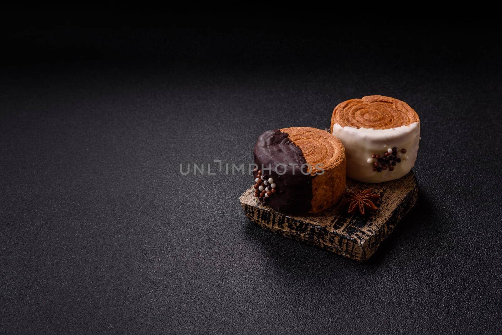 Round sweet New York roll croissant with chocolate cream filling on a dark concrete background