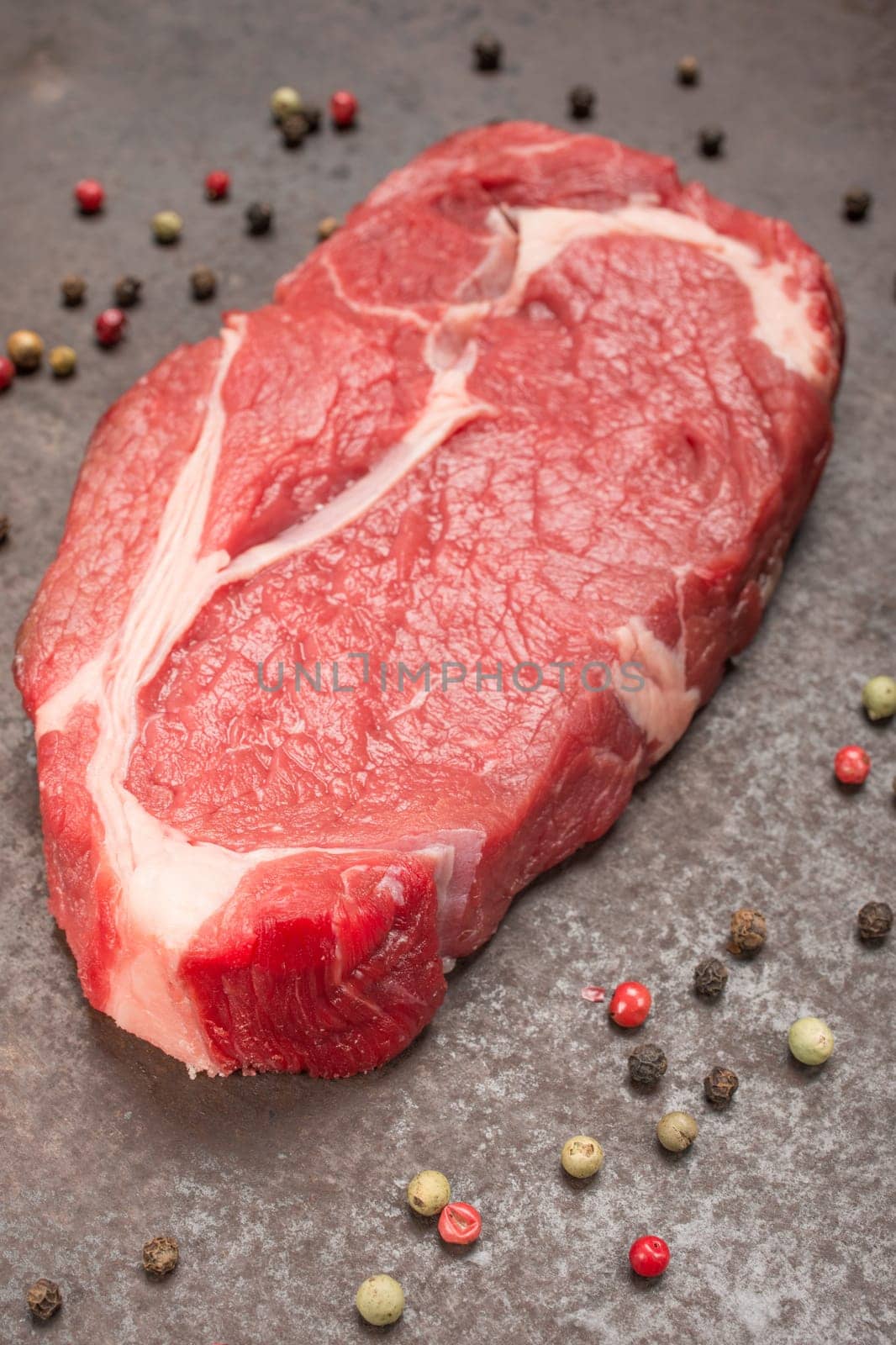 Dry aged steak and peppercorns in portrait format