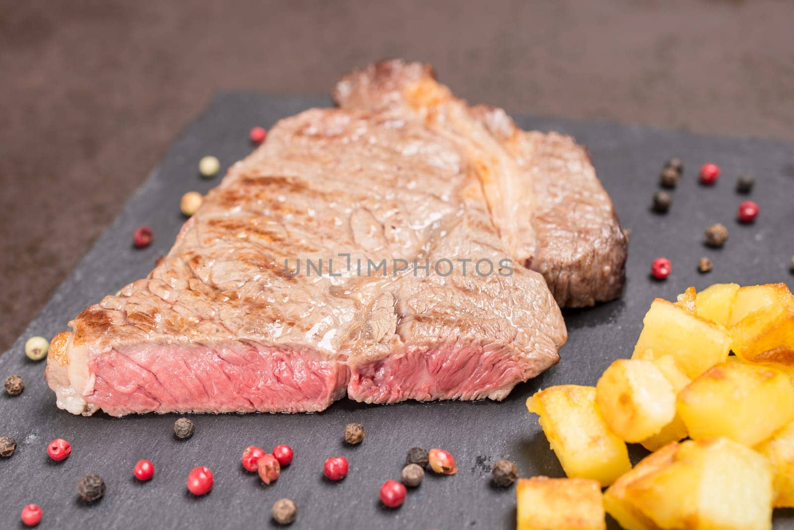 Rib eye steak of beef pink fried with pepper and potatoes